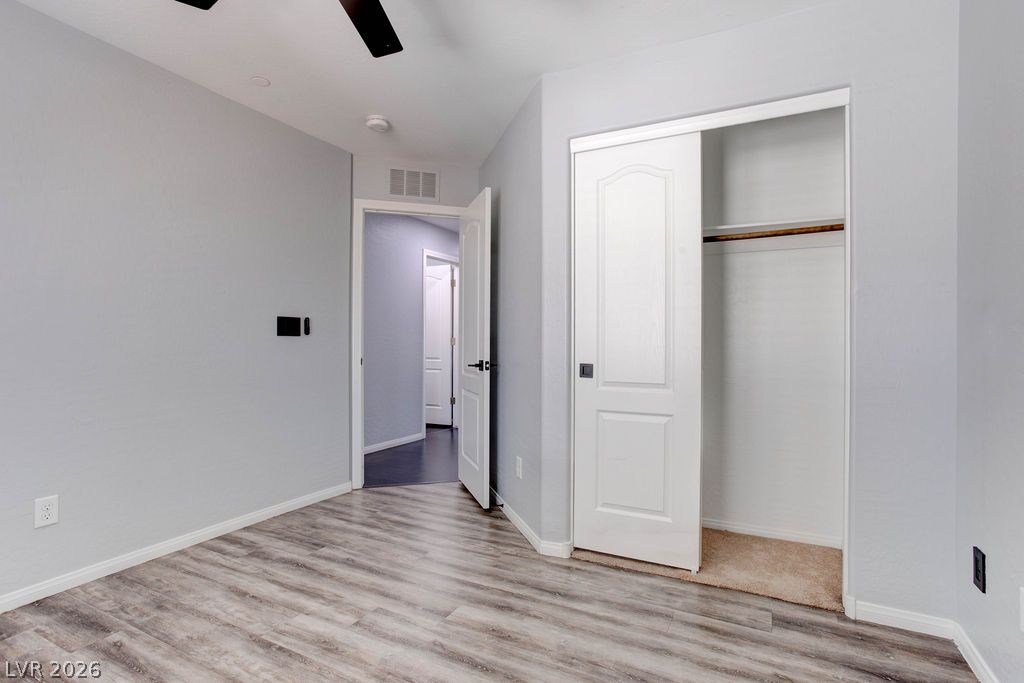 7724 Vibrant Thread Court Las Vegas, NV 89149 - Photo 33 of 43 A well-lit bedroom features durable laminate flooring and ample closet space with sliding doors.