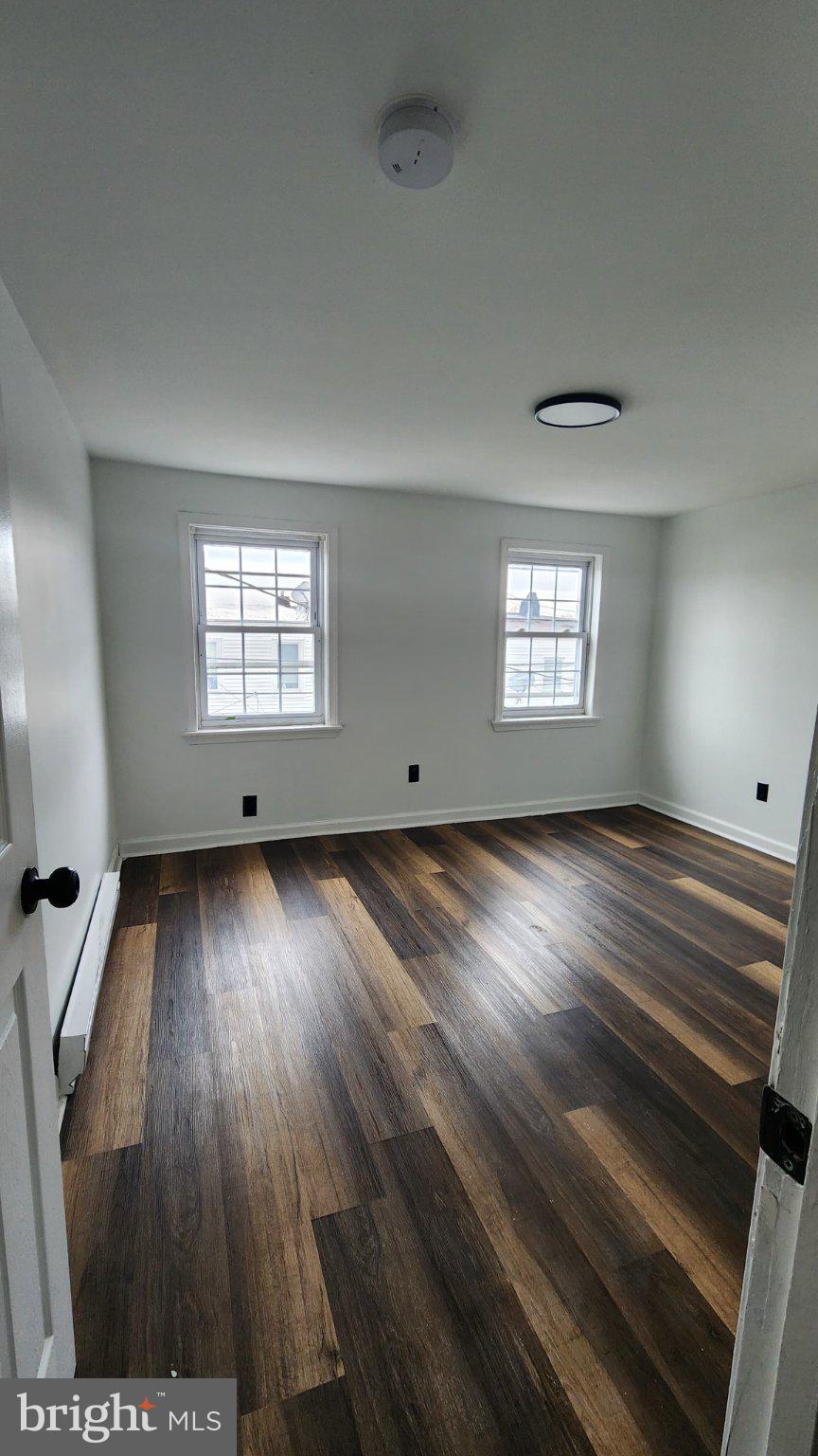 3502 East Lombard Street Baltimore, MD 21224 - Photo 3 of 10 wooden floor in an empty room with a window