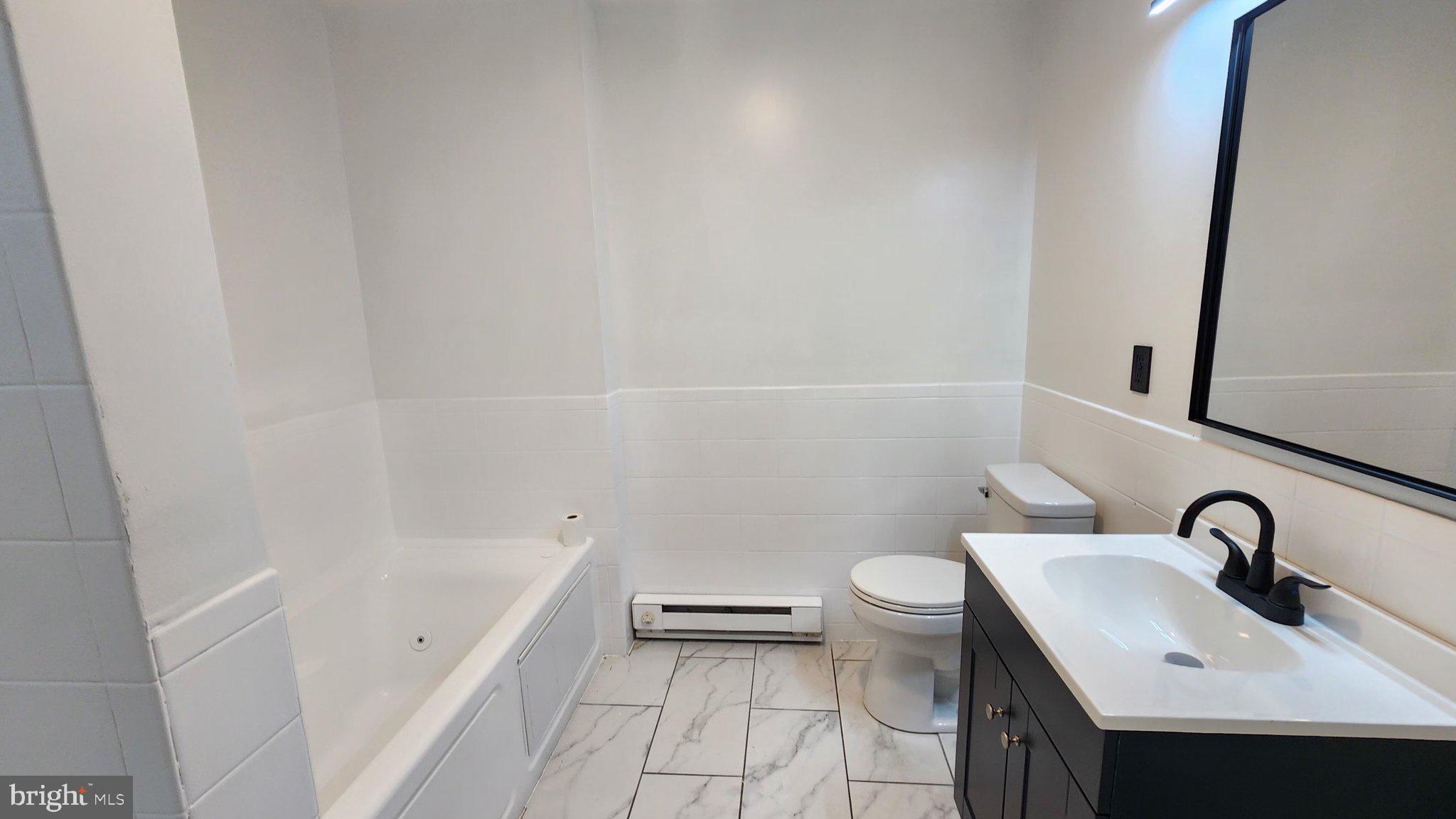 3502 East Lombard Street Baltimore, MD 21224 - Photo 6 of 10 a bathroom with a sink a toilet and shower