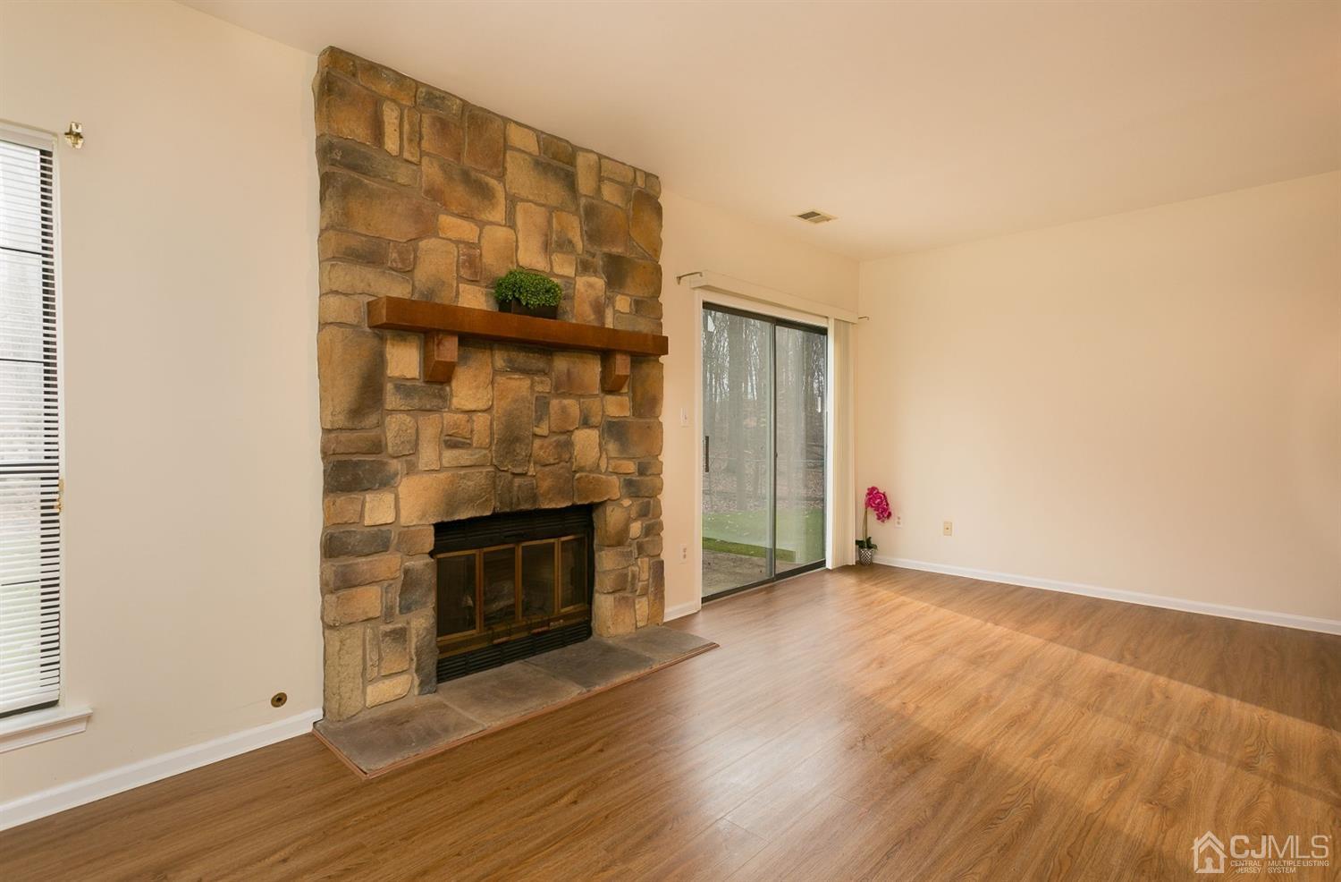1307 Timber Oaks Road Edison, NJ 08820 - Photo 14 of 26 an empty room with wooden floor fireplace and windows