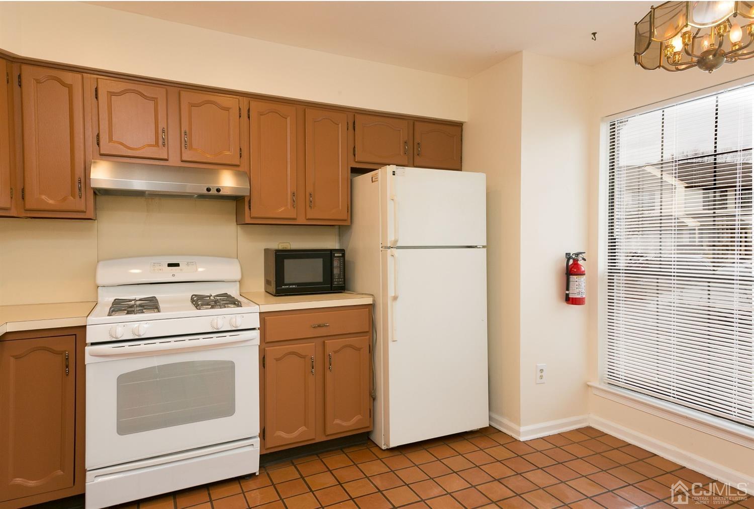 1307 Timber Oaks Road Edison, NJ 08820 - Photo 8 of 26 a kitchen with a refrigerator sink stove and cabinets