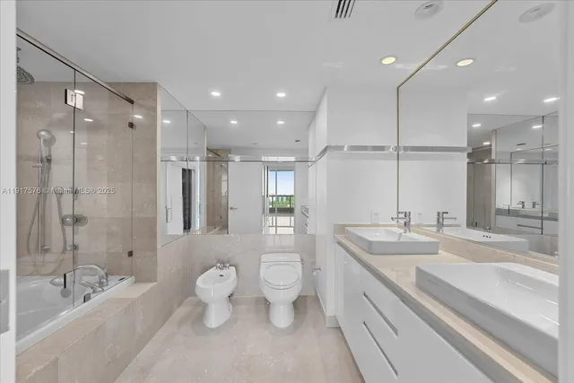 a spacious bathroom with a double vanity sink toilet mirror and bathtub