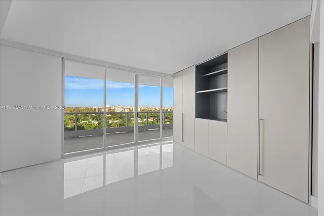 an empty room with sliding door and wooden floor