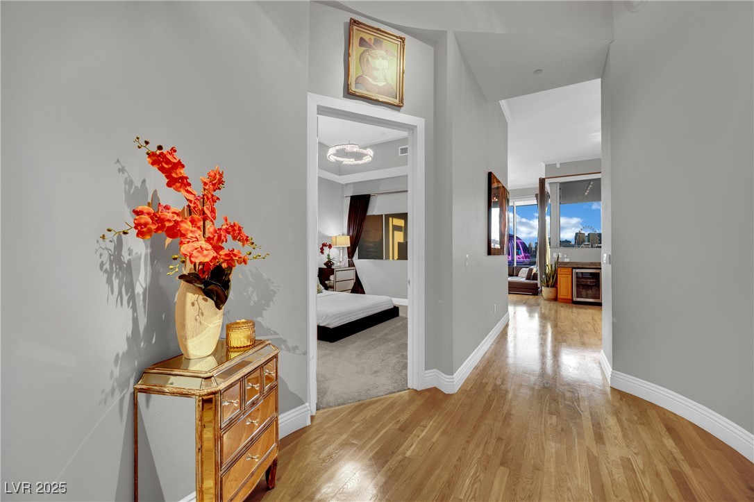 360 East Desert Inn Road, Unit 1803 Las Vegas, NV 89109 - Photo 23 of 67 Corridor with light wood-style flooring, baseboards, and beverage cooler