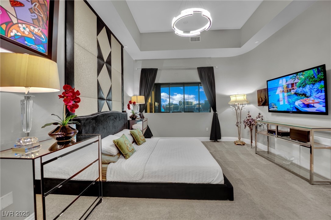 360 East Desert Inn Road, Unit 1803 Las Vegas, NV 89109 - Photo 26 of 67 Carpeted bedroom featuring a tray ceiling and baseboards
