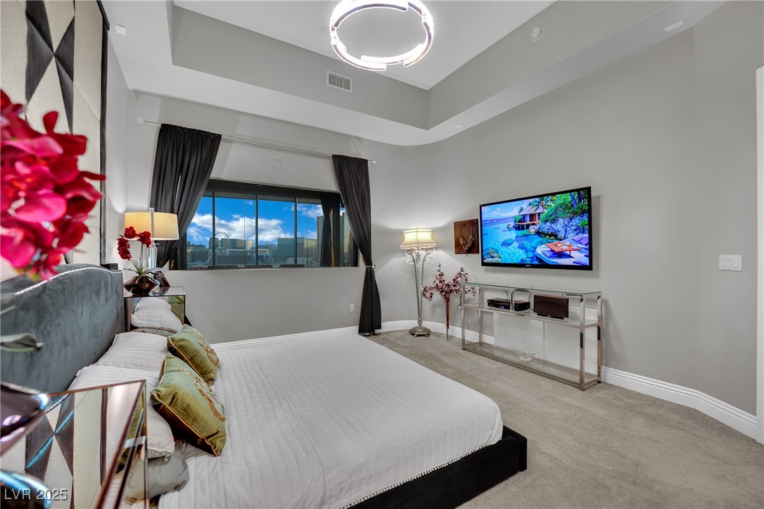 360 East Desert Inn Road, Unit 1803 Las Vegas, NV 89109 - Photo 30 of 67 Carpeted bedroom featuring baseboards and a tray ceiling