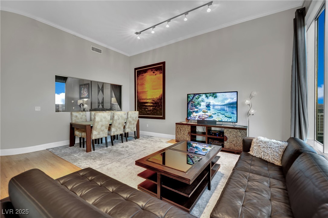 360 East Desert Inn Road, Unit 1803 Las Vegas, NV 89109 - Photo 32 of 67 Living area with wood finished floors, crown molding, baseboards, and track lighting