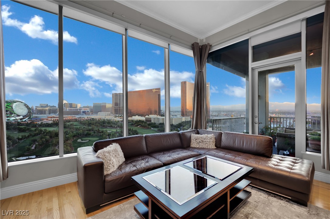 360 East Desert Inn Road, Unit 1803 Las Vegas, NV 89109 - Photo 35 of 67 Sunroom featuring ornamental molding, wood finished floors, a city view, baseboards, and plenty of natural light