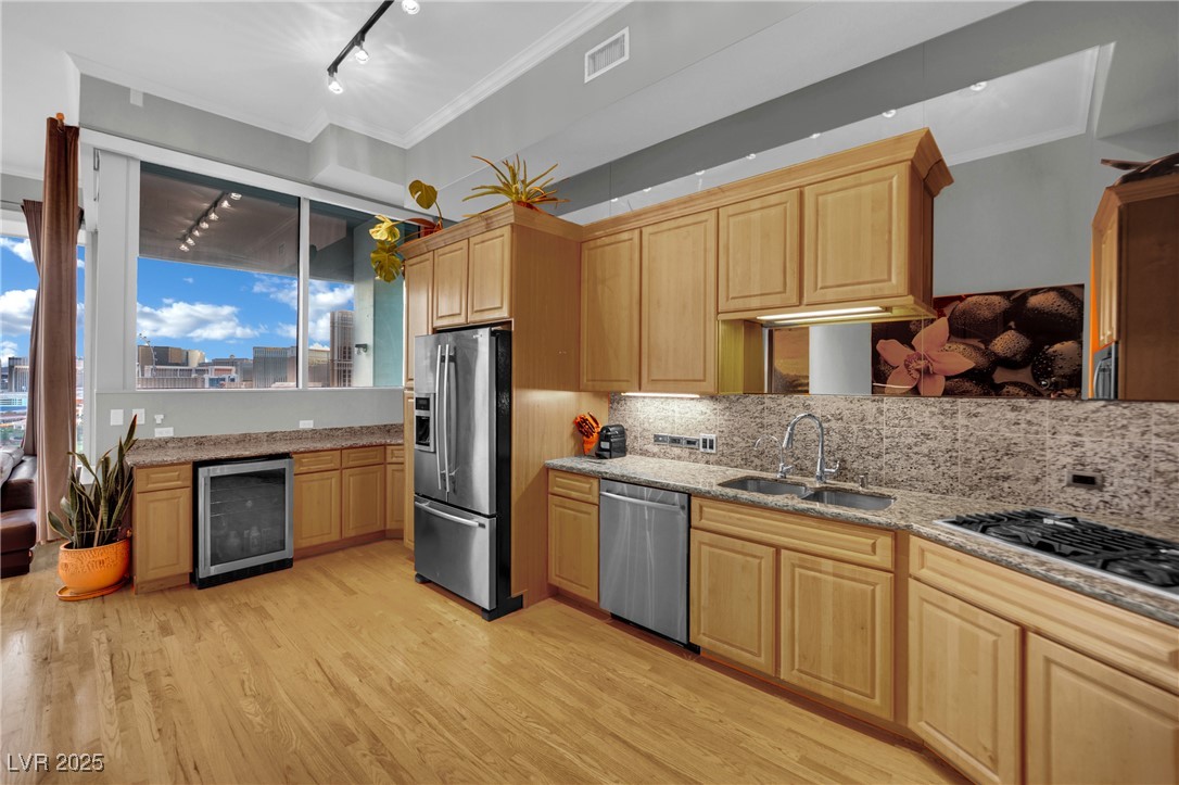 360 East Desert Inn Road, Unit 1803 Las Vegas, NV 89109 - Photo 38 of 67 Kitchen with stainless steel appliances, beverage cooler, ornamental molding, a sink, and light brown cabinetry