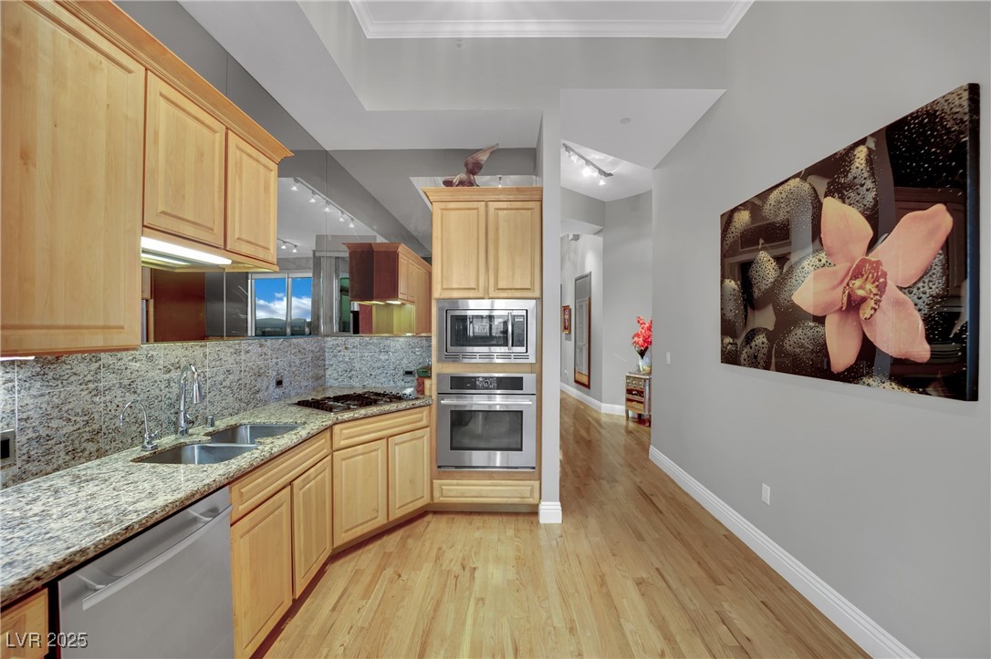 360 East Desert Inn Road, Unit 1803 Las Vegas, NV 89109 - Photo 41 of 67 Kitchen with stainless steel appliances, light brown cabinetry, a sink, and light wood-style floors