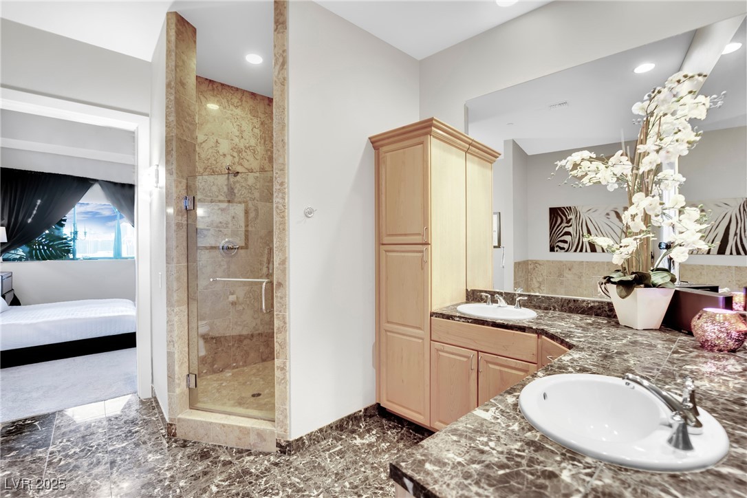 360 East Desert Inn Road, Unit 1803 Las Vegas, NV 89109 - Photo 48 of 67 Ensuite bathroom featuring a shower stall, marble tiled flooring, double vanity, recessed lighting, and baseboards