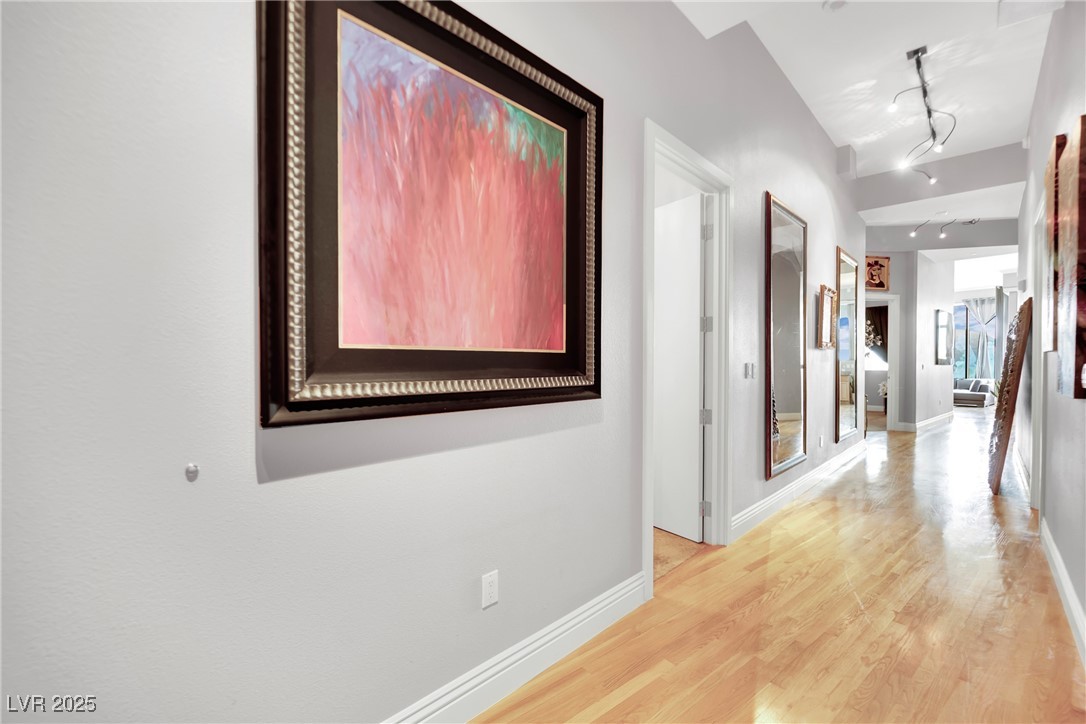 360 East Desert Inn Road, Unit 1803 Las Vegas, NV 89109 - Photo 52 of 67 Hall featuring light wood-style floors, rail lighting, and baseboards