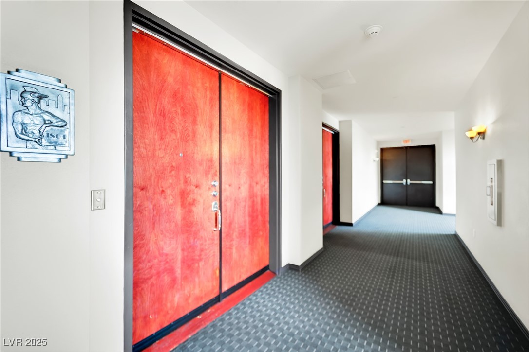 360 East Desert Inn Road, Unit 1803 Las Vegas, NV 89109 - Photo 56 of 67 Hallway featuring dark carpet and baseboards