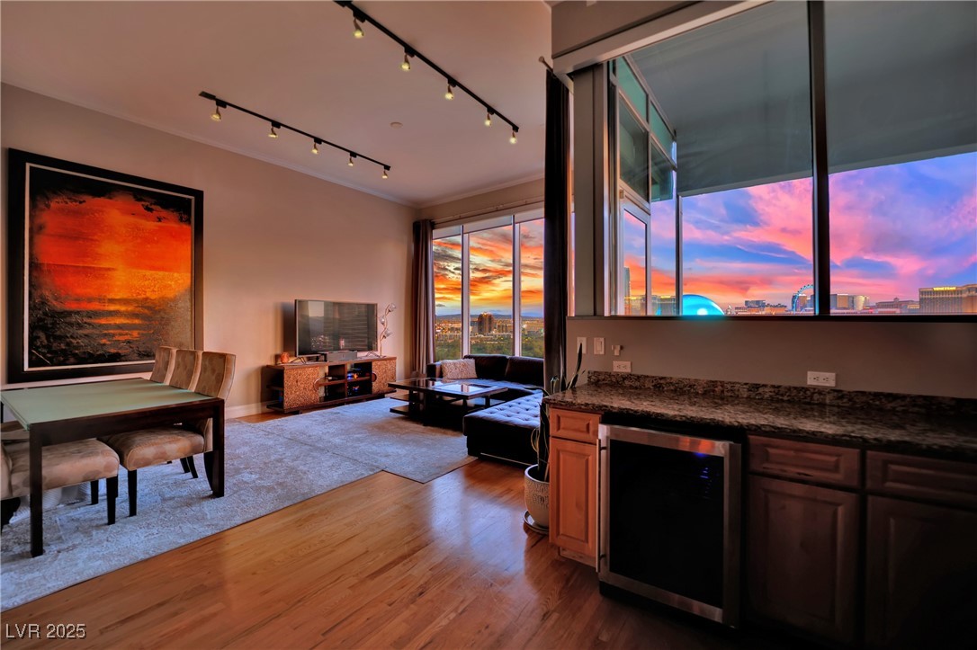 360 East Desert Inn Road, Unit 1803 Las Vegas, NV 89109 - Photo 6 of 67 Living room featuring wine cooler, wood finished floors, bar, and track lighting