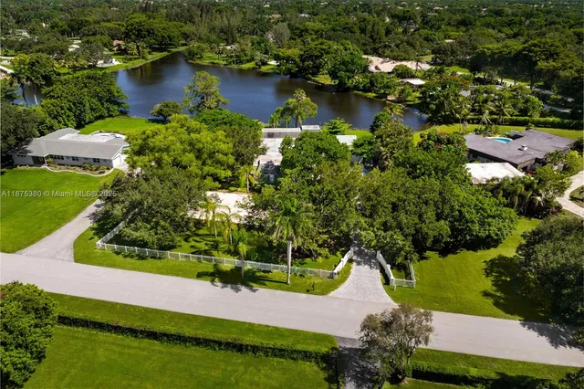 an aerial view of residential houses with outdoor space and lake view