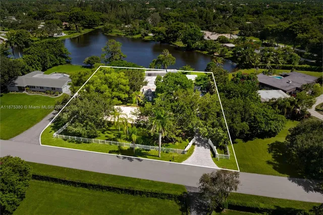 an aerial view of a house with a yard and lake view