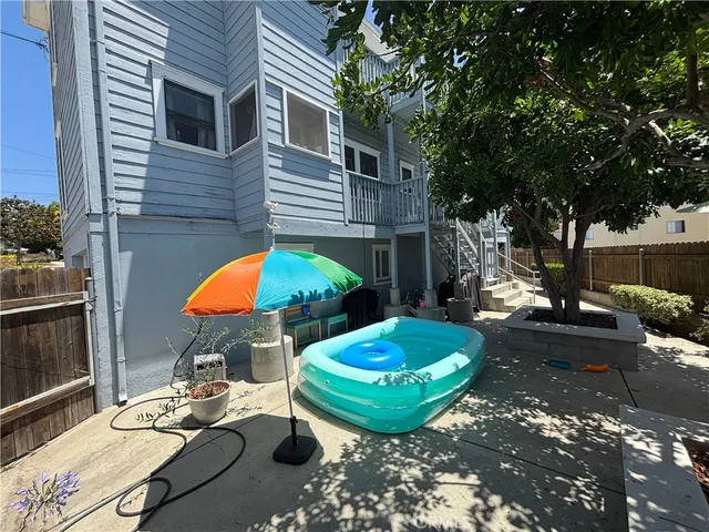 a view of a backyard with table and chairs under an umbrella