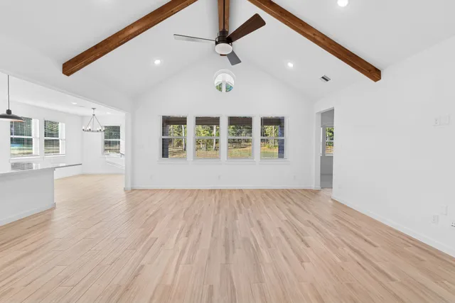 a large white kitchen with kitchen island a stove a sink dishwasher and wooden floor