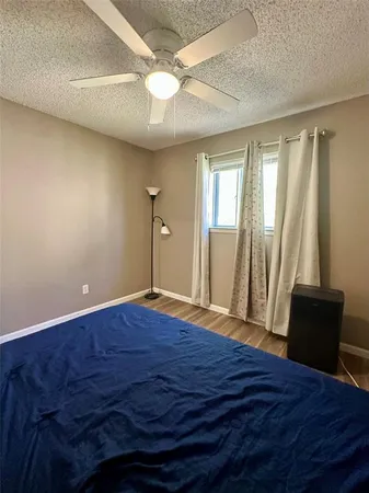 a view of a room with wooden floor and a ceiling fan