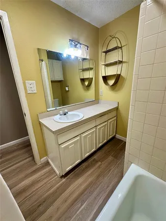 a bathroom with a double vanity sink a mirror and a bathtub