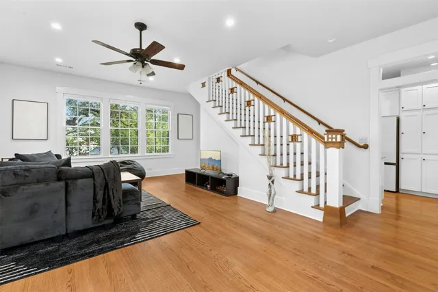 a living room with wooden floor and a large window