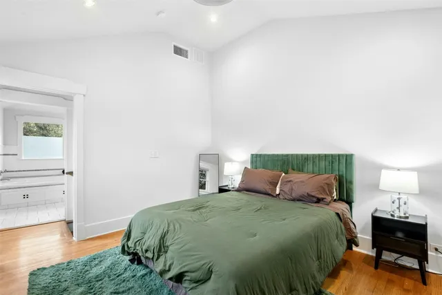 a bedroom with a bed and wooden floor