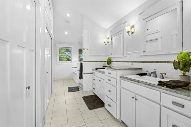 a kitchen with white cabinets and appliances