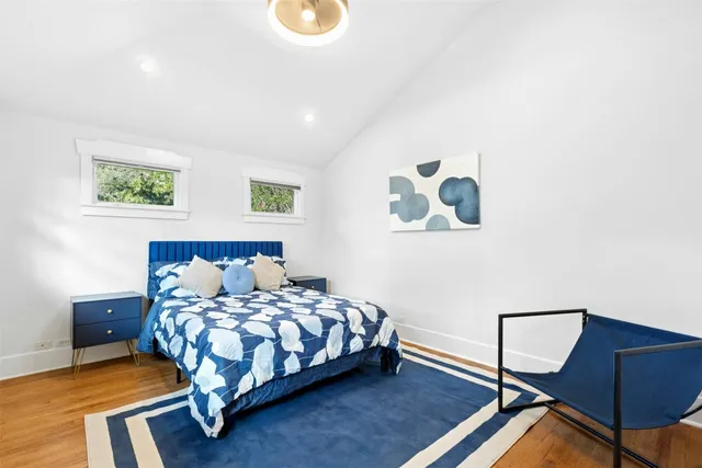 a bedroom with a bed and painting on the wall