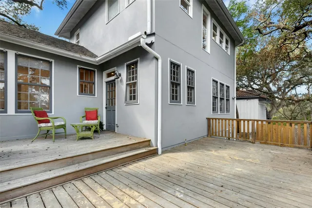 a view of a house with a wooden deck and furniture