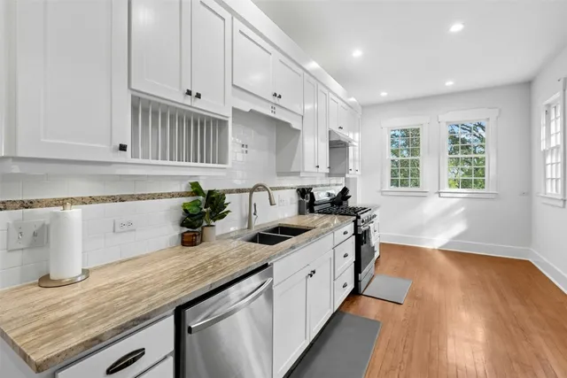 a kitchen with granite countertop a sink stainless steel appliances and cabinets