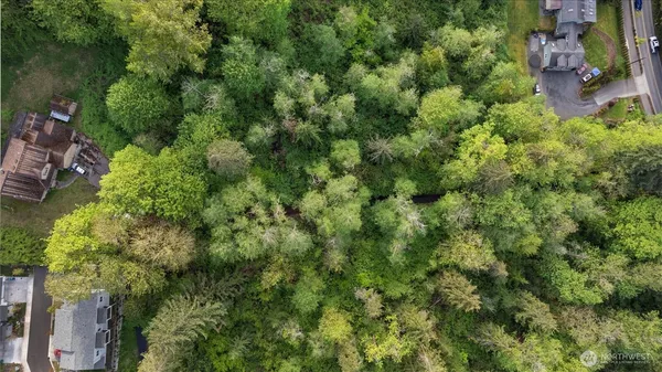 an aerial view of residential house with outdoor space and trees all around