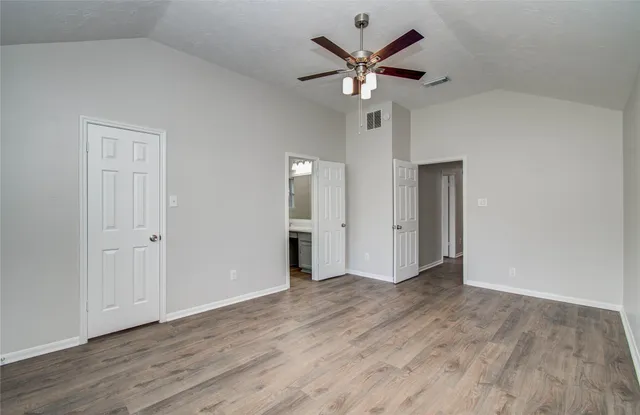 a view of an empty room with wooden floor