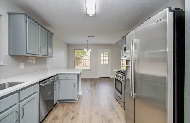 a kitchen with a refrigerator a sink and cabinets