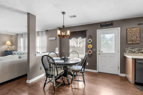 a dining room with furniture a chandelier and wooden floor