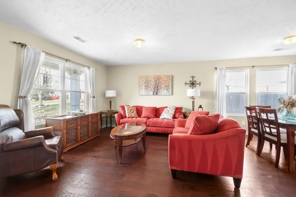 a living room with furniture a rug and a window