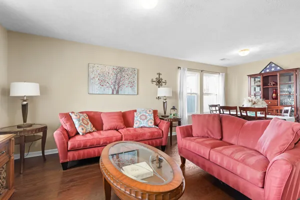 a living room with furniture a couch and wooden floor