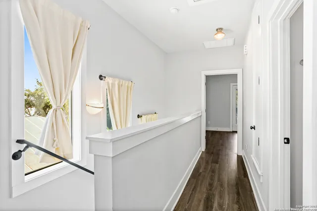 a view of a hallway with wooden floor and staircase