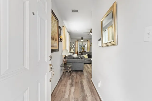 a view of a living room with a bed and wooden floor