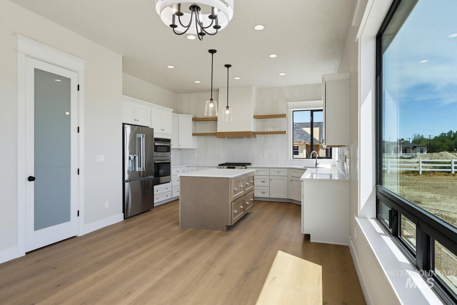 5054 Heritage Drive Marsing, ID 83639 - Photo 8 of 38 Modern kitchen featuring a central island with integrated storage, stainless steel appliances, and white cabinetry