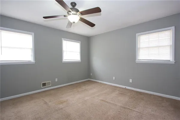 an empty room with closet and a chandelier fan