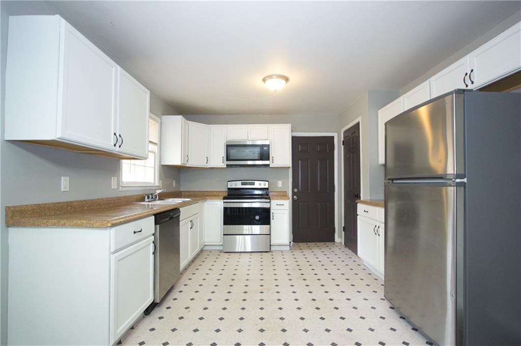 2974 McGlynn Court Decatur, GA 30034 - Photo 5 of 28 a kitchen with granite countertop a refrigerator and a stove top oven