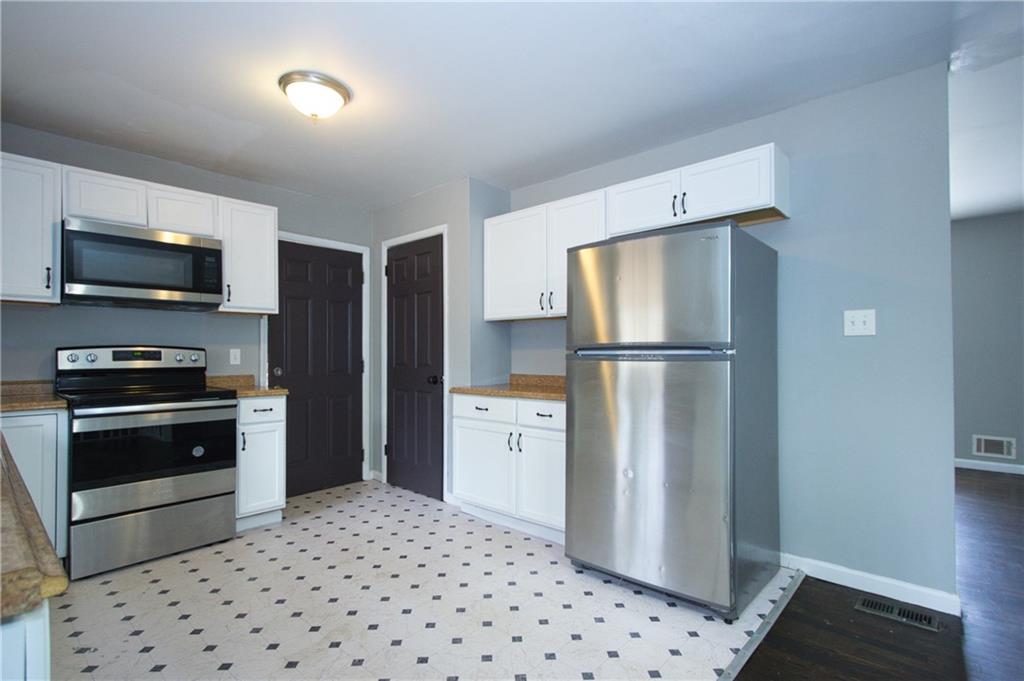 2974 McGlynn Court Decatur, GA 30034 - Photo 6 of 28 a kitchen with a refrigerator a stove top oven and cabinets