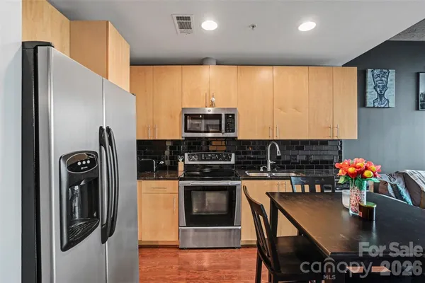 a kitchen with stainless steel appliances granite countertop a refrigerator and a stove top oven