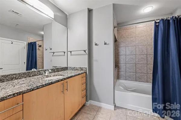a bathroom with a granite countertop bathtub shower and sink