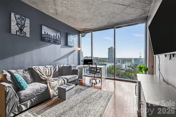 a living room with furniture a flat screen tv and a floor to ceiling window