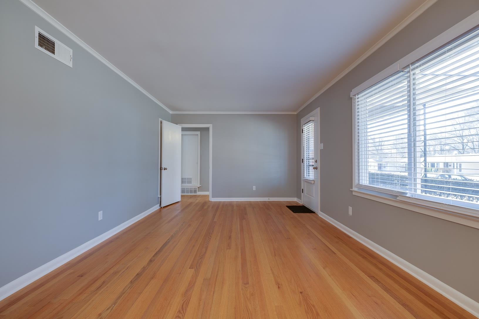 1490 Wilbec Road Memphis, TN 38117 - Photo 3 of 19 a view of an empty room with wooden floor and a window