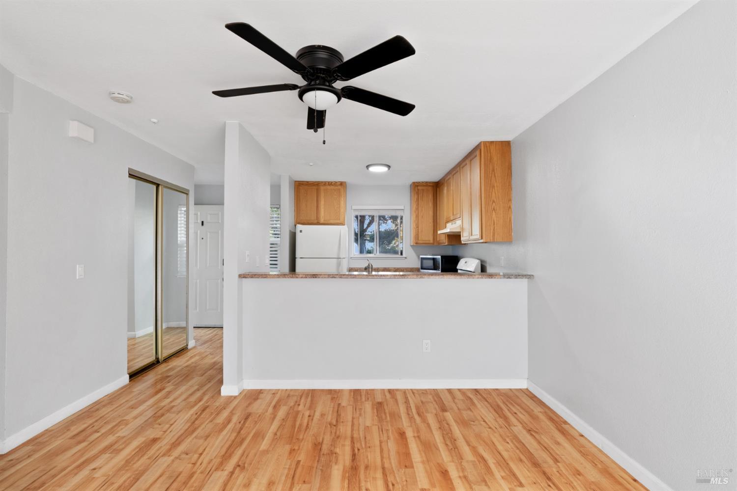 7651 Camino Colegio Rohnert Park, CA 94928 - Photo 4 of 15 a big room with wooden floor a ceiling fan and kitchen view