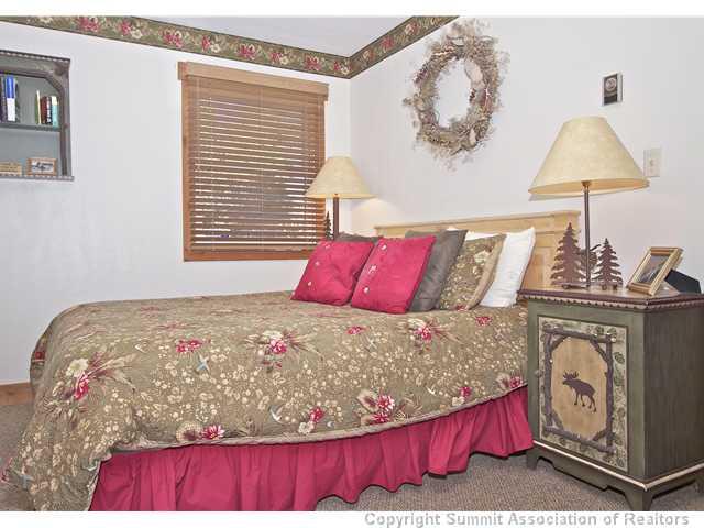 407 4 O'Clock Run Road Breckenridge, CO 80424 - Photo 21 of 25 a bed sitting in a bedroom next to a window with a chandelier