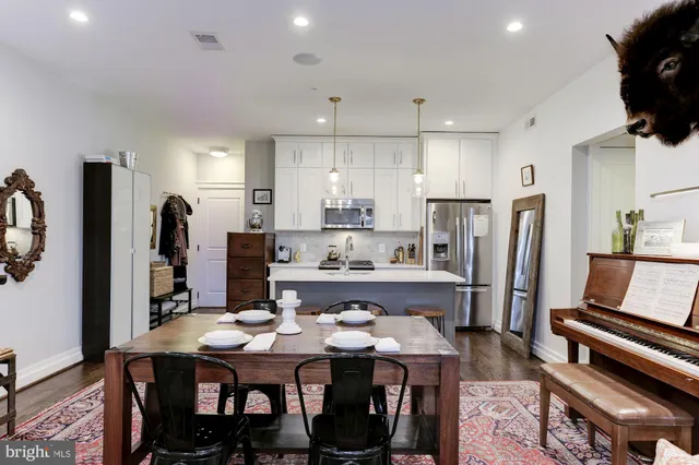 a kitchen with a dining table chairs and refrigerator