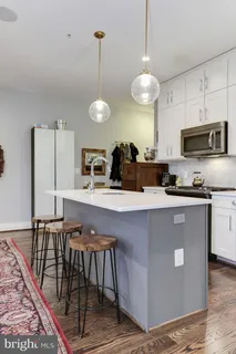 a kitchen with stainless steel appliances granite countertop white cabinets and a stove a oven with white countertops